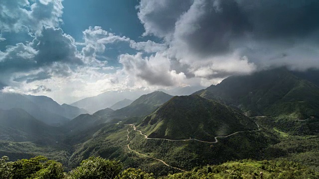 时光流逝景观精彩的拍摄攀登山脉。多云的天空和阳光越过迷雾山路在高岩石山视频素材