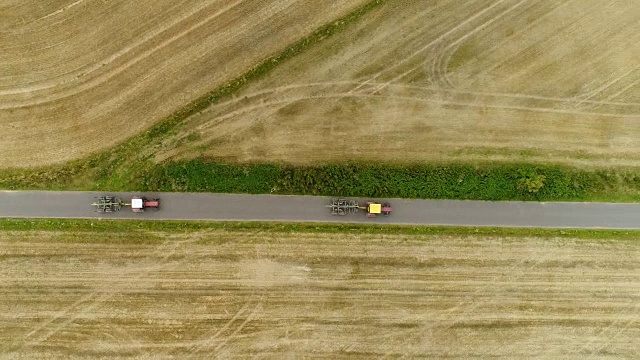 拖拉机通过道路的鸟瞰图。农用拖拉机在田里工作。视频素材