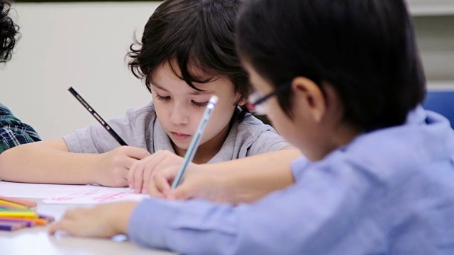 学校的孩子们，快乐的小男孩用颜色和蜡笔画画视频素材