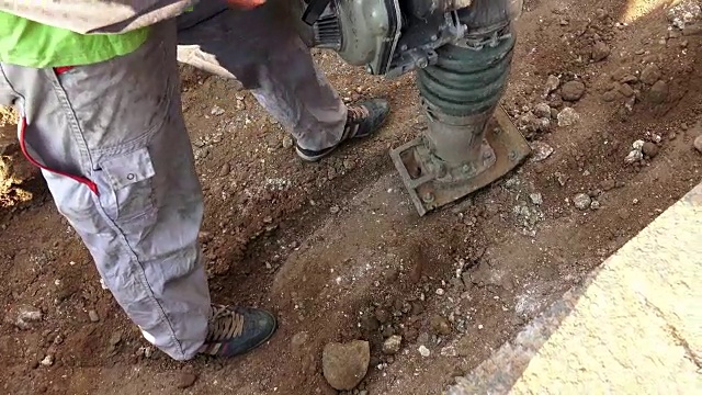 操作重型碎石压实机的道路施工工人视频素材