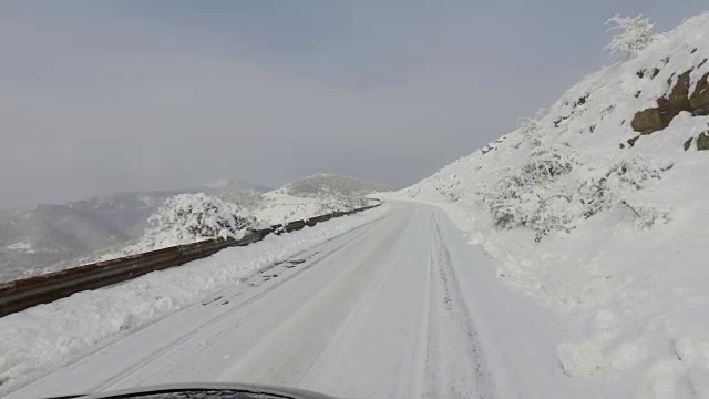 POV驾驶在积雪覆盖的山区乡村道路上视频素材