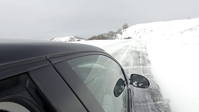 白天在雪山路上行驶的汽车的POV视频素材