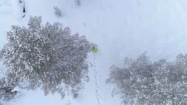 航拍:在芬兰的冬天，一个面目全非的人在深雪中跋涉视频素材