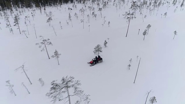 近距离观察:游客们驾驶着雪上摩托，穿梭在满是积雪的山上视频素材