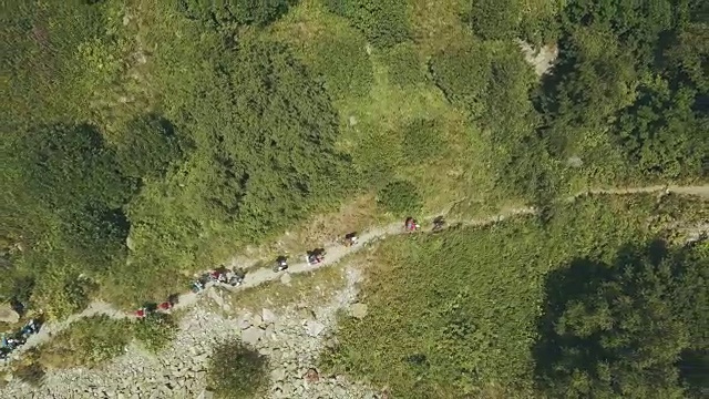 从上往下看，徒步行走的队伍在山间小径上。爬山视频素材