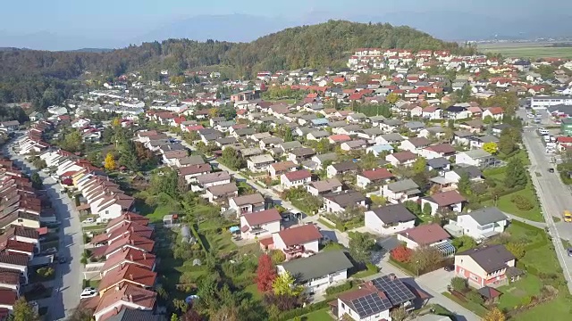 航拍:在田园诗般的郊区小镇上空飞行，那里有排屋和绿色花园视频素材