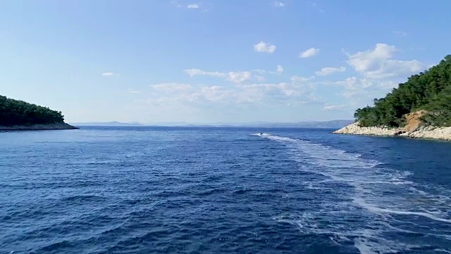 鸟瞰图一个人在美丽的海湾和蓝色的海水和热带岛屿滑雪背景视频素材