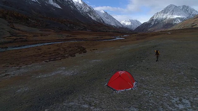 帐篷附近的男子以山景为背景。空中FullHD视频素材