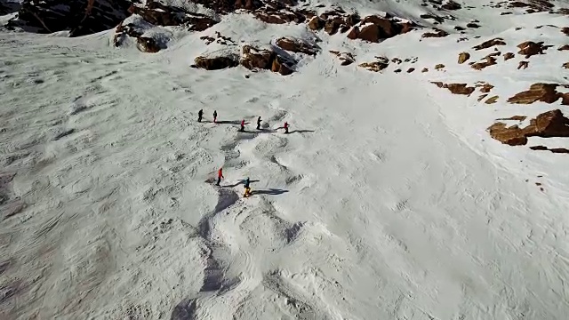 在阿尔卑斯山的一个斜坡上飞过一群滑雪者视频素材