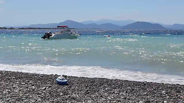 一艘小防波堤船停泊在满是泡沫的海滩附近视频素材