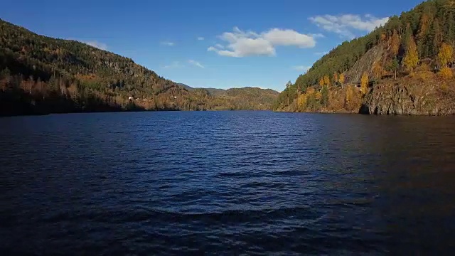 低空飞过荡漾的水面，向群山飞去。视频素材