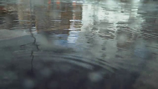 下雨时在柏油路上踩水坑视频素材