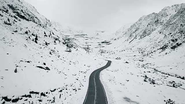 飞过空空如也的发夹曲线之间的雪山视频素材