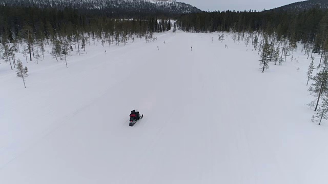 近距离观察:男人和女人在雪地摩托上穿越冰雪世界视频素材