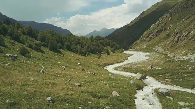 顶景游客在山里旅游。沿着山河行走的游客视频素材