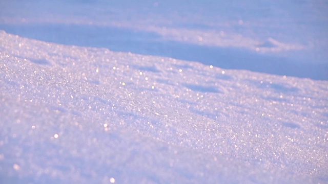 冬季早晨，在阳光明媚的山坡上，蓝色的雪花晶体闪闪发光视频素材