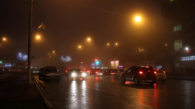 雾中的城市路灯和道路上的汽车。视频下载