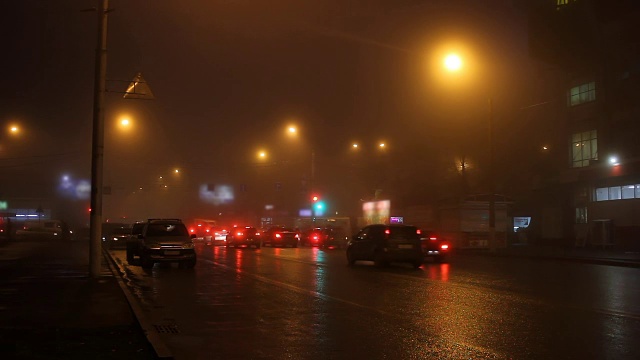 雾中的城市路灯和道路上的汽车。视频素材