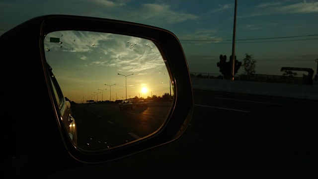 从侧镜看高速公路上的夕阳视频素材