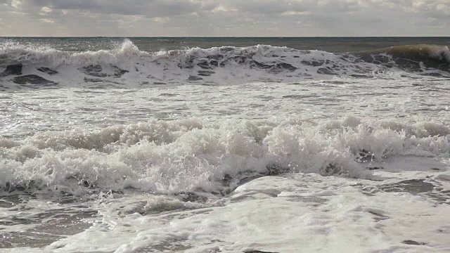 慢镜头中，巨大的泡沫浪滚向岸边视频素材