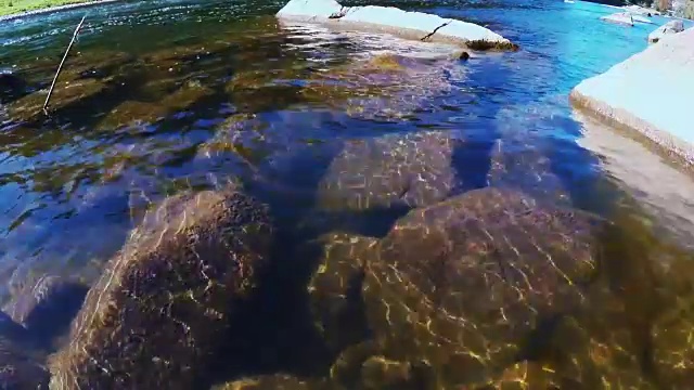 在阳光明媚的秋日，石头在透明的水山上河视频素材