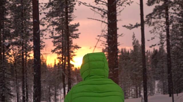 慢镜头:一个面目全非的人在金色的夕阳下向空中抛雪视频素材