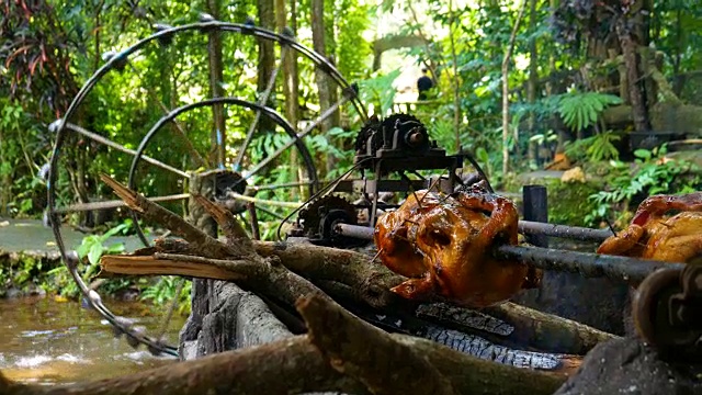 鸡肉烤架与滚动棒，由自然水轮机旋转视频素材