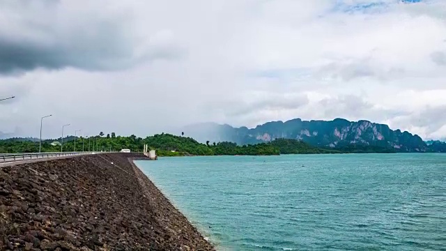 时间推移拍摄的大坝与热带森林和山与雨和风暴云的背景视频素材