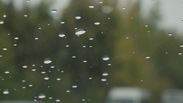 下雨天驾驶汽车慢动作，挡风玻璃视野-汽车前灯，树木视频下载