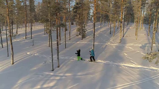 天线:活跃的夫妇在温暖的冬天穿着雪鞋在厚厚的雪地上徒步旅行视频素材