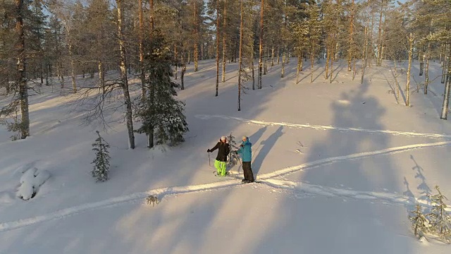 阳光明媚的早晨，年轻人穿着雪鞋探索冰雪覆盖的拉普兰森林视频素材