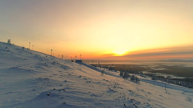 天线:在冬日的夕阳下，活跃的女性穿着雪鞋在白雪覆盖的山坡上徒步视频素材