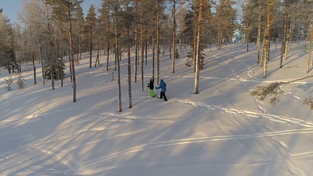 摄影:在阳光明媚的早晨，年轻的旅行者们穿着雪鞋探索冰雪覆盖的拉普兰森林视频素材