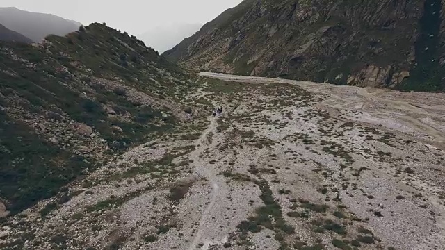 无人机观看徒步行走的人背景山河。攀登山视频素材