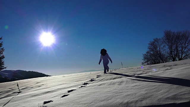 在雪地里行走的徒步旅行者。探险的旅程。脚脚陡峭。雪的冬天。体育娱乐活动。太阳背光的剪影对着相机。超高清4K库存素材视频素材