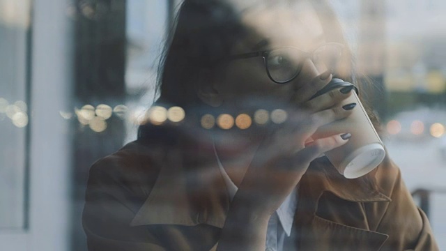 在窗边喝咖啡的女人视频素材