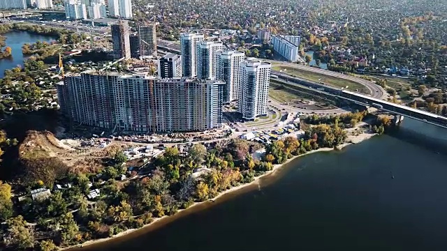 在河岸上建造一个多套公寓的综合体。许多建筑起重机。鸟瞰图视频下载