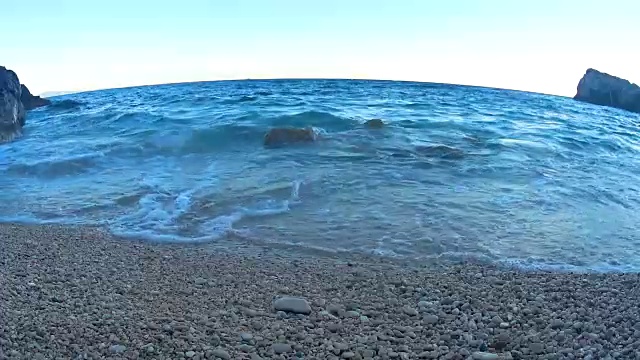 海洋沙滩。日落时海浪拍打着卵石海岸。视频素材