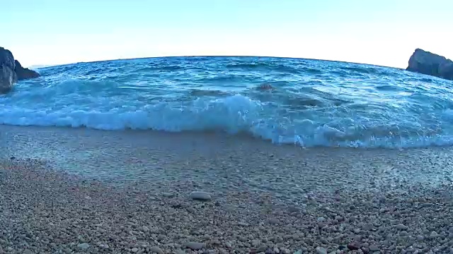 海洋沙滩。日落时海浪拍打着卵石海岸。视频素材