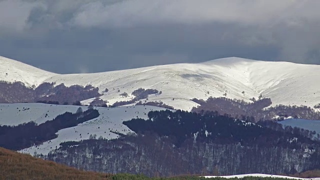 雪山覆盖，山脊和全景在美丽的冬日与蓝天。超高清平移股票视频视频素材