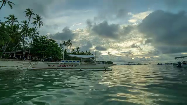 人们在河南海滩享受抛锚的游艇视频素材