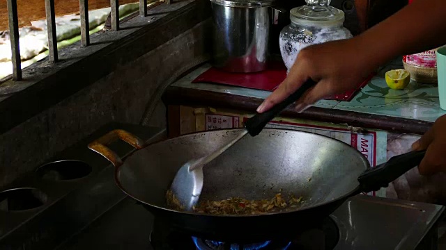 一名亚洲男子在热煎锅上煎大蒜和辣椒视频素材