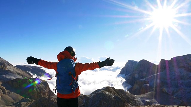 一位女性登山者在山顶张开双臂视频素材