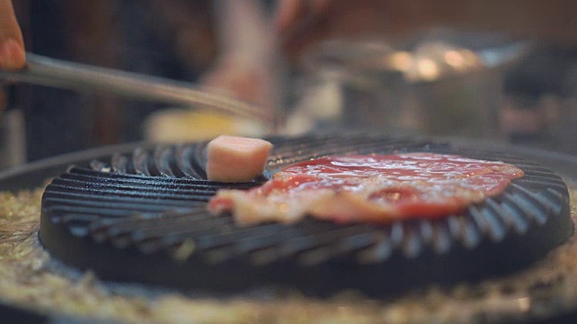 烹饪烧烤，在炉子上的木炭上烤。关闭牛肉烤在日本餐厅。用于烧烤或日式食物的生牛肉片视频素材