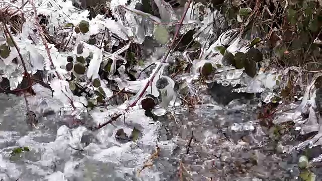 一条美丽晶莹的河流流淌着冰雪融解的冬雪，4k背景视频素材