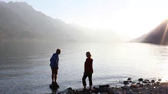 夫妇横越湖岸，在湖边拍照视频素材