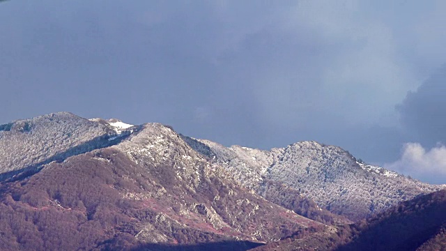 冬天的风景山峰上覆盖着白雪和深蓝色的天空。时间流逝视频素材