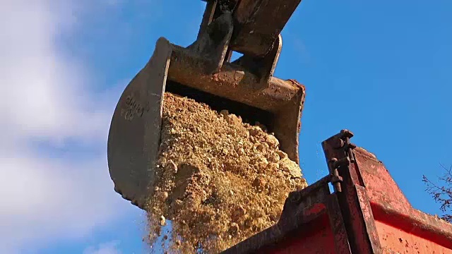 挖掘机在运输卡车上装载地面视频素材