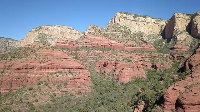 在红色岩石景观的峡谷上向后飞行视频素材