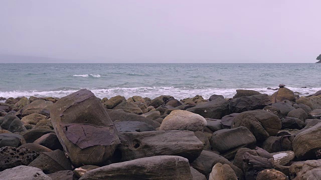 汹涌的海水在阴沉的天空下拍打着岩石海岸视频素材